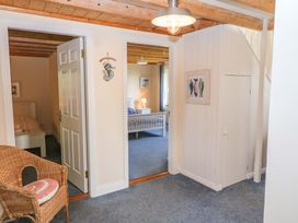 A hallway with a staircase and doorway to a bedroom at Whispering Pines in Durrus, County Cork
