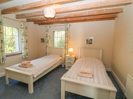 A bedroom featuring two single beds and a nightstand at Whispering Pines in Durrus, County Cork