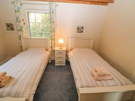 A bedroom with two beds and a lamp at Whispering Pines in Durrus, County Cork
