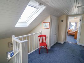 A hallway with a red chair and skylight at Whispering Pines in Durrus, County Cork