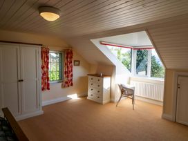 A bedroom with a wardrobe and a window at Whispering Pines, Durrus, County Cork