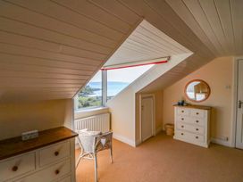 A bedroom with a window, chair, and chest of drawers at Whispering Pines, Durrus, County Cork