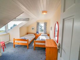A bedroom with two beds and a window at Whispering Pines in Durrus, County Cork