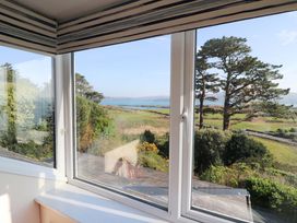 A view from a window showing trees and a landscape at Whispering Pines in Durrus, County Cork