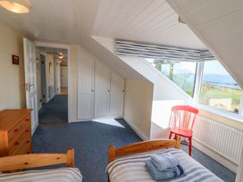 A bedroom with two beds and a chair at Whispering Pines in Durrus, County Cork