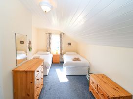 A bedroom with two beds and a dresser at Whispering Pines, Durrus, County Cork