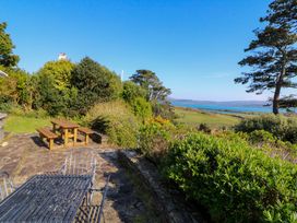 A garden with a table and benches overlooking the sea at Whispering Pines, Durrus, County Cork