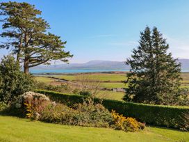 A garden with trees and bushes overlooking the sea at Whispering Pines in Durrus, County Cork