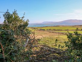 A view of hills and water with bushes in the foreground at Whispering Pines, Durrus, County Cork