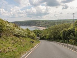 A road leading to a beach with cliffs in the background at Rose Lodge Runswick Bay near Staithes