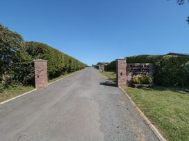 A driveway lined with hedges leading to a sign at Rose Lodge Runswick Bay near Staithes