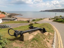 A beach view with an anchor and houses at Honeysuckle Lodge in Runswick Bay near Staithes