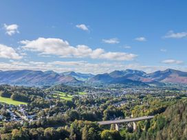 A panoramic view of mountains and a valley with a bridge in the landscape at Canadian Cabin 37, Keswick