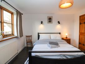 A bedroom with a bed towels on it a wooden chair window bedside table and lamp at The Apple House in Spaxton near Nether Stowey