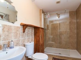 A bathroom with a sink toilet wooden cabinet and glass shower at The Apple House in Spaxton near Nether Stowey