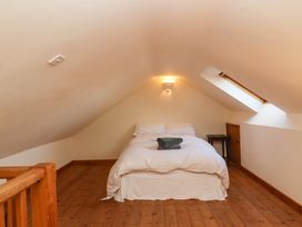 A bedroom with a bed and folded towels under a slanted ceiling with a skylight at The Apple House in Spaxton near Nether Stowey