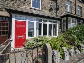 A front entrance with a red door and flowers at Badgers, Sedbergh, Yorkshire Dales