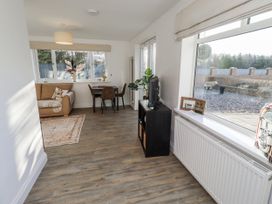 A living room with a sofa and dining table at Old Colliery Cottage in Shilbottle