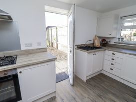 A kitchen with cabinets and a gas stove at Old Colliery Cottage in Shilbottle