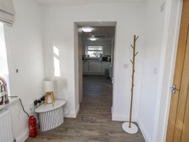 A hallway with a lamp and coat rack at Old Colliery Cottage in Shilbottle