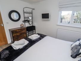 A bedroom with towels and a television at Old Colliery Cottage in Shilbottle