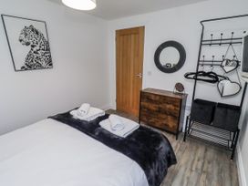 A bedroom with a bed and dresser at Old Colliery Cottage in Shilbottle