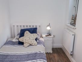 A bedroom with a bed and bedside table at Old Colliery Cottage in Shilbottle