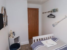 A bedroom with a bed and decorative items at Old Colliery Cottage in Shilbottle
