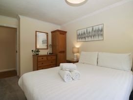 A bedroom with a bed and wooden furniture at Beech Timber Lodge in Keswick