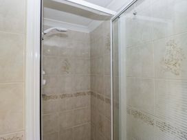 A shower area with tiles and glass door at Beech Timber Lodge in Keswick
