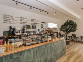 A café counter with a display case and coffee machine at Elm Lodge in Keswick