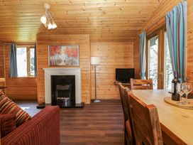 A living room with a sofa and dining table at Elm Lodge in Keswick