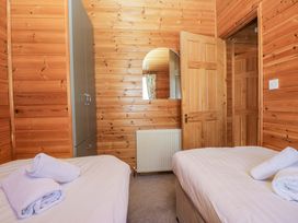 A bedroom with twin beds and a wardrobe at Elm Lodge in Keswick