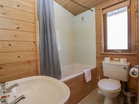 A bathroom with a bathtub, toilet, and sink at Elm Lodge in Keswick