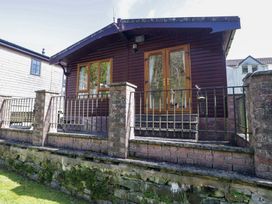A cabin with a porch and railing at Elm Lodge in Keswick