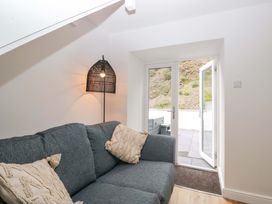 A living room with a sofa and a door leading outside at Riverside Cottage No 5 in Keswick