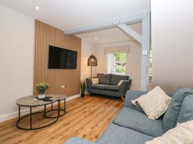 A living room with a sofa and television at Riverside Cottage No 5 Keswick