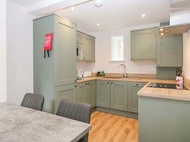 A kitchen with green cabinets and a sink at Riverside Cottage No 5 in Keswick