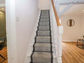 A staircase with a handrail and carpet leading to an upper level at Riverside Cottage No 5 in Keswick