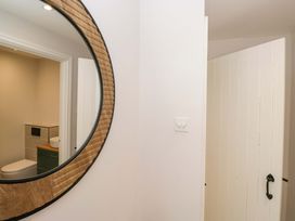 A bathroom with a mirror and doorway at Riverside Cottage No 5 in Keswick