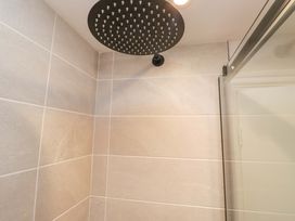 A shower head and tiles in a bathroom at Riverside Cottage No 5 in Keswick