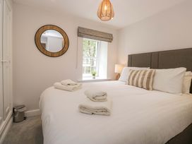 A bedroom with a bed and lamp at Riverside Cottage No 5 in Keswick