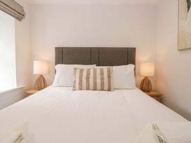A bedroom with a bed and bedside lamps at Riverside Cottage No 5, Keswick