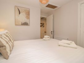 A bedroom with a bed and wall art at Riverside Cottage No 5 in Keswick