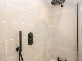 A shower area with tiles and a shower head at Riverside Cottage No 5 in Keswick