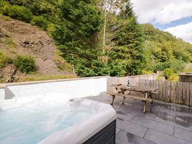 An outdoor area with a hot tub and picnic bench at Riverside Cottage No 5 in Keswick
