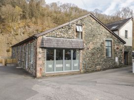 A stone building with large windows and a café sign at The Bobbin Mill Café in Keswick
