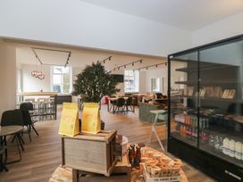 A café with tables and chairs and a fridge at Briery House in Keswick