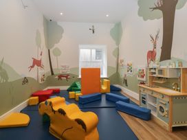 A playroom with soft play blocks and a kitchen play set at Briery House in Keswick