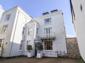 An exterior view of a white house with a balcony at 2 St Michaels House in Lyme Regis